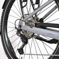 Gros plan sur la roue arrière et le dérailleur Shimano Deore du vélo électrique Loop Sports Scott Axis 10 gris