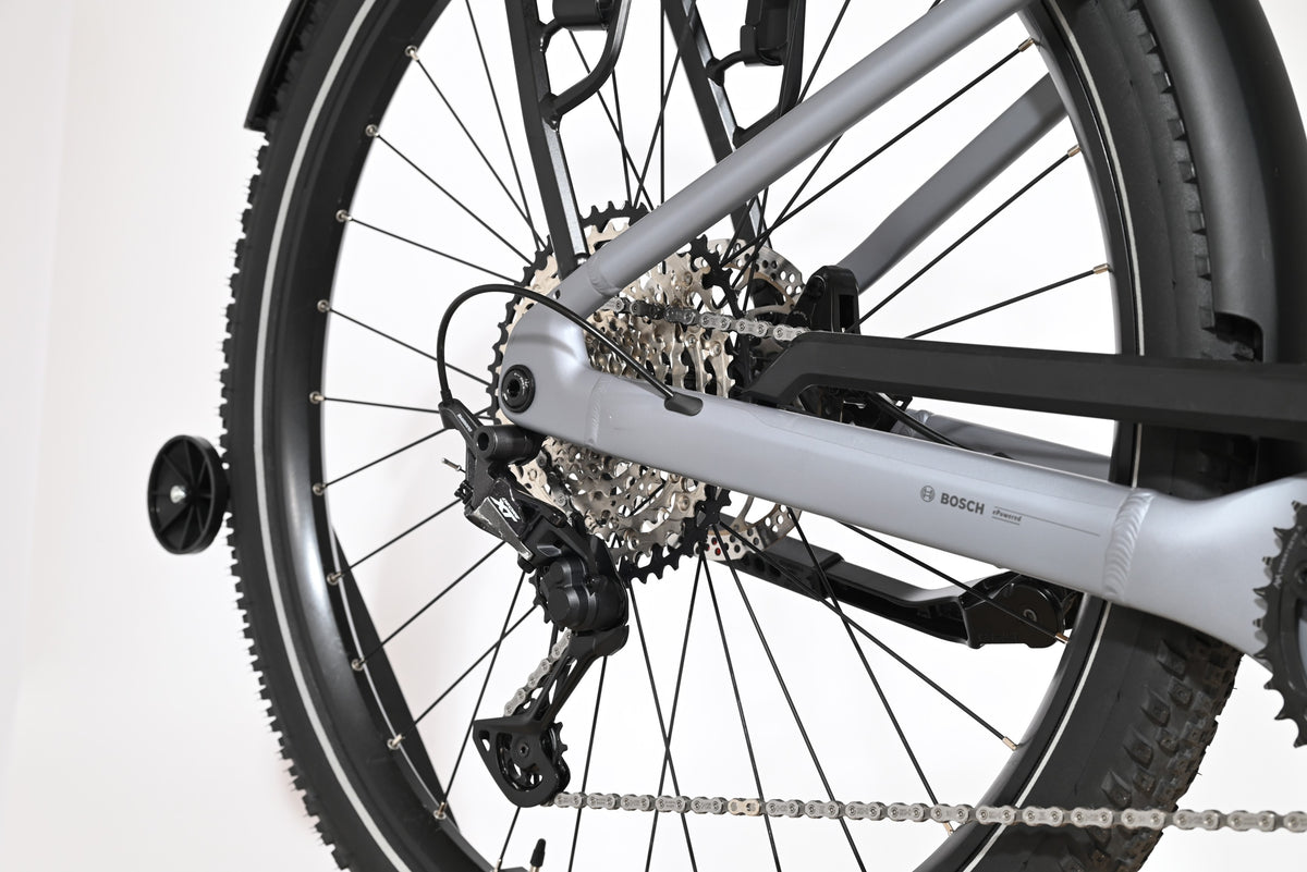 Gros plan sur la roue arrière et le dérailleur Shimano Deore du vélo électrique Loop Sports Scott Axis 10 gris