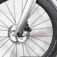 Gros plan sur la roue avant et le frein à disque hydraulique du vélo de course Loop Sports Scott Foil RC Ultimate