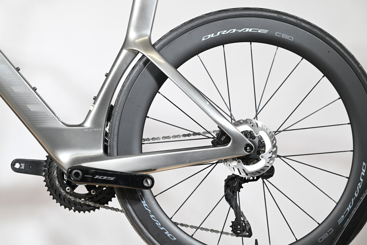 Gros plan sur le cadre gris carbone et la roue arrière Dura-Ace C60 du vélo de route Loop Sports Scott Foil RC