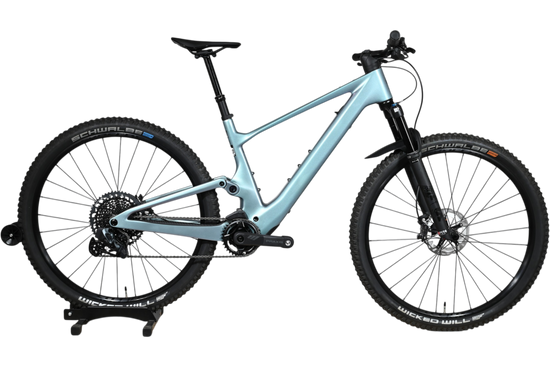 VTT électrique Scott Lumen eRide 900 bleu clair de Loop Sports sur un support en bois
