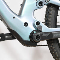 Gros plan sur le cadre bleu irisé et le pédalier en carbone Praxis du vélo électrique Loop Sports Scott Lumen eRide