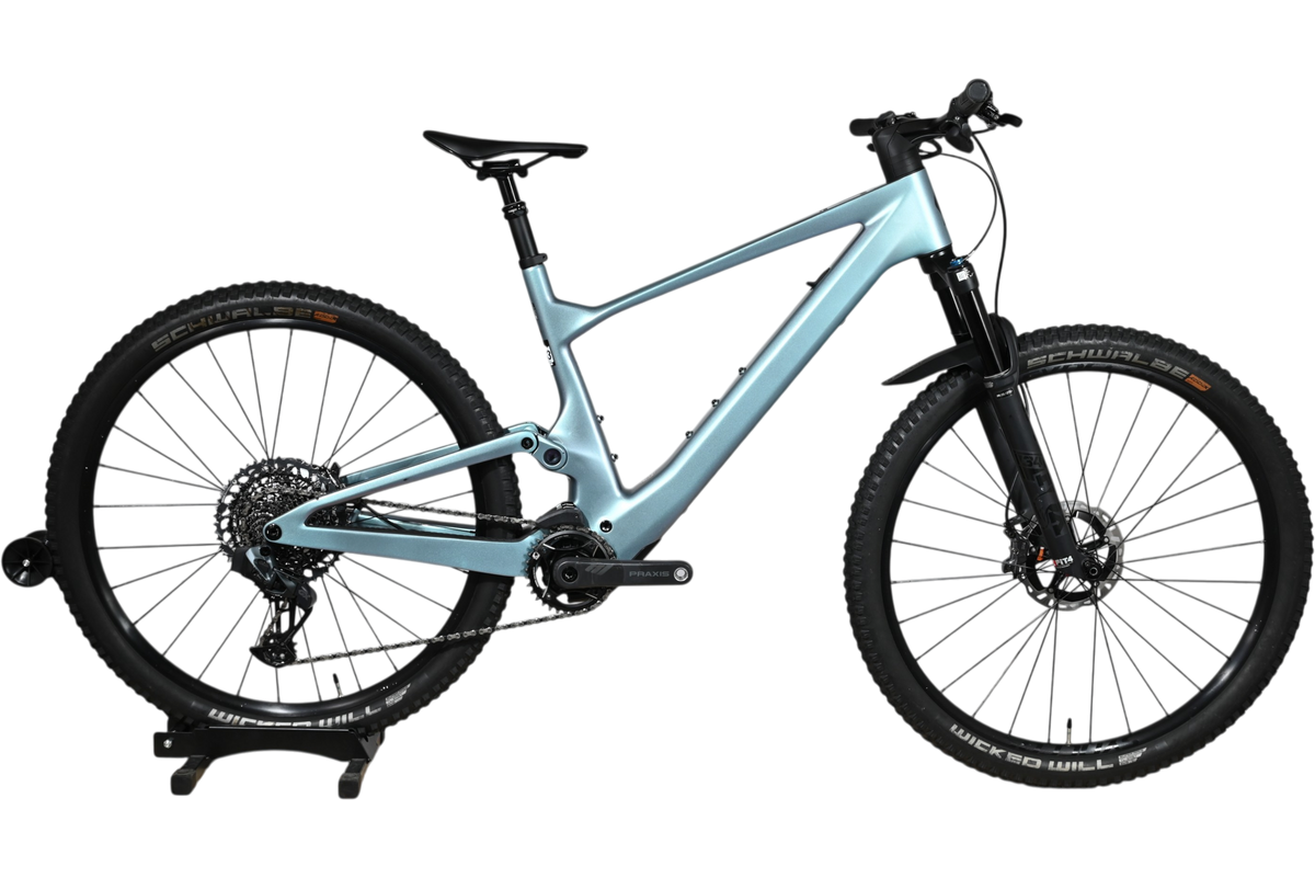 VTT électrique Scott Lumen eRide 900 bleu clair de Loop Sports sur un support en bois