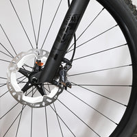 Gros plan sur le frein à disque avant et la fourche noire du vélo électrique Scott Lumen eRide 900 chez Loop Sports