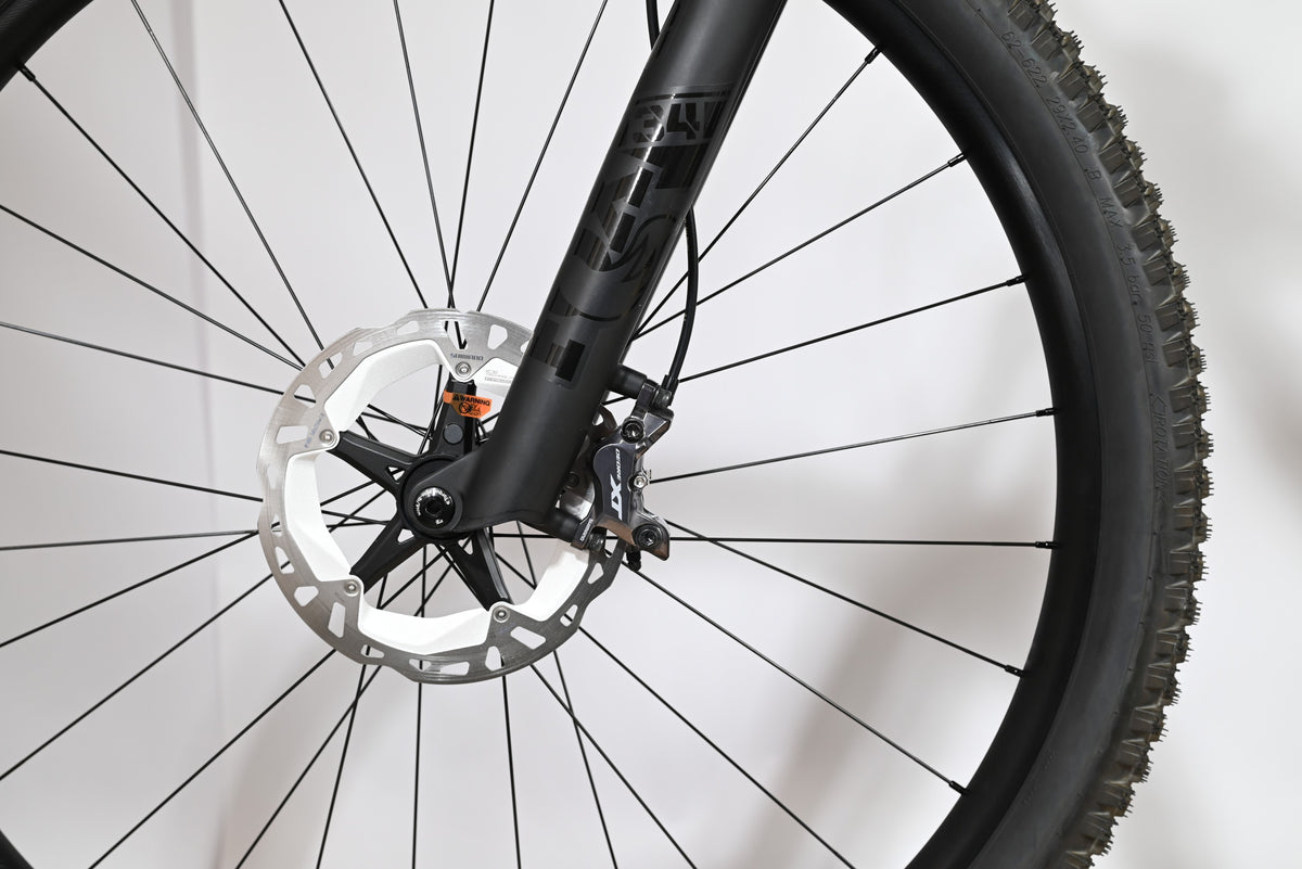 Gros plan sur le frein à disque avant et la fourche noire du vélo électrique Scott Lumen eRide 900 chez Loop Sports
