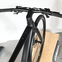 Vue plongeante sur le guidon et le cadre noir mat du vélo hybride Scott Metrix 30 EQ 2024 chez Loop Sports