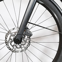 Gros plan sur la roue avant et le frein à disque hydraulique du vélo Loop Sports Scott Metrix 30 EQ 2024