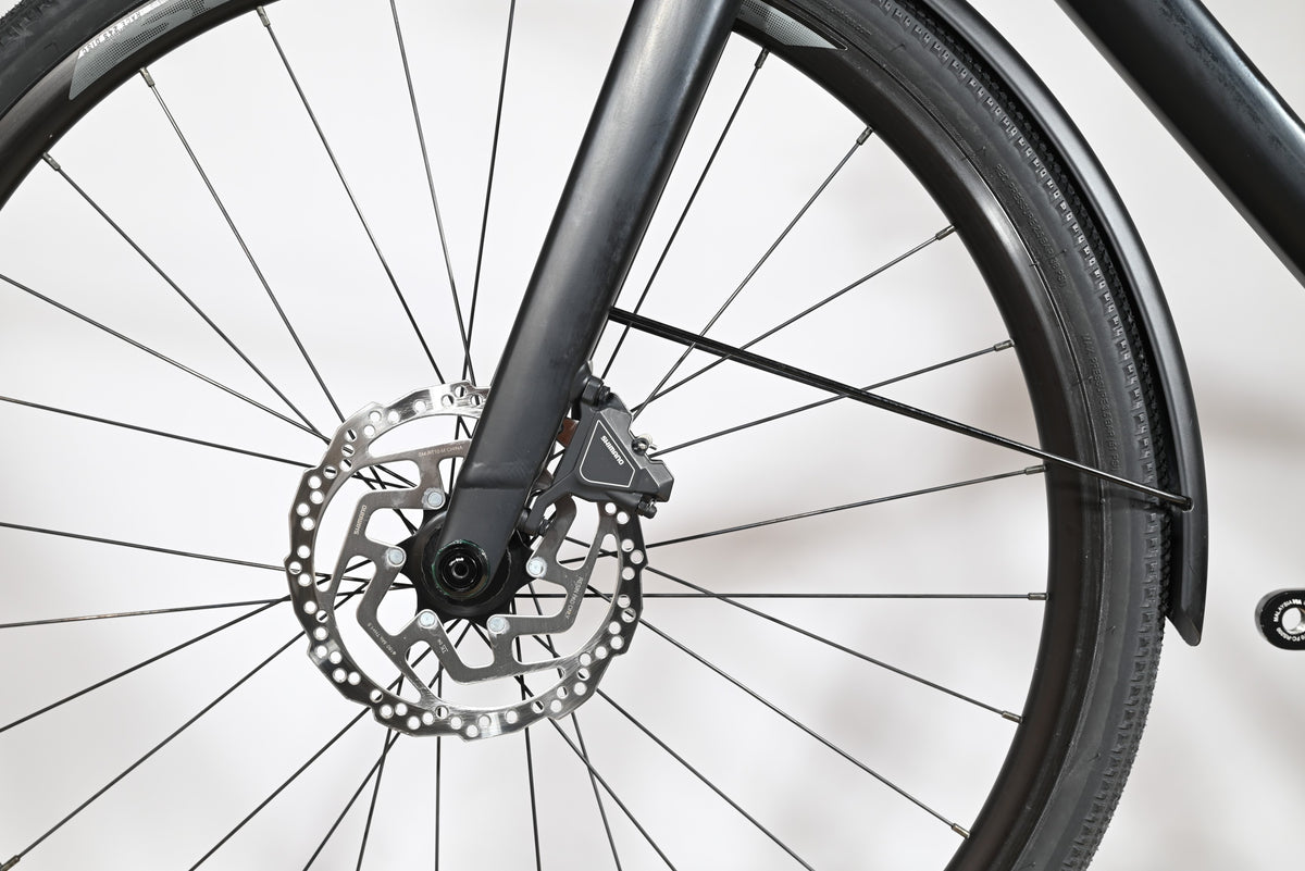 Gros plan sur la roue avant et le frein à disque hydraulique du vélo Loop Sports Scott Metrix 30 EQ 2024