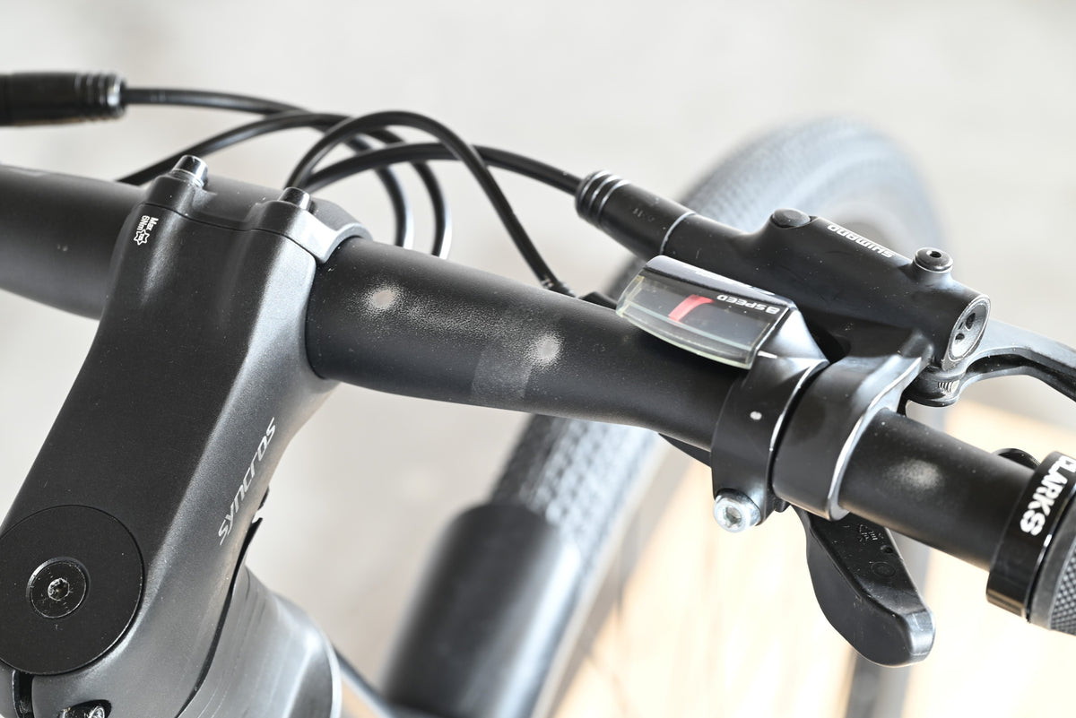 Vue rapprochée du guidon noir du vélo Scott Metrix 30 EQ 2024 avec manettes de vitesse Loop Sports
