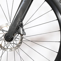 Gros plan sur le frein à disque hydraulique SRAM et la fourche en carbone du vélo gravel Loop Sports Scott Solace