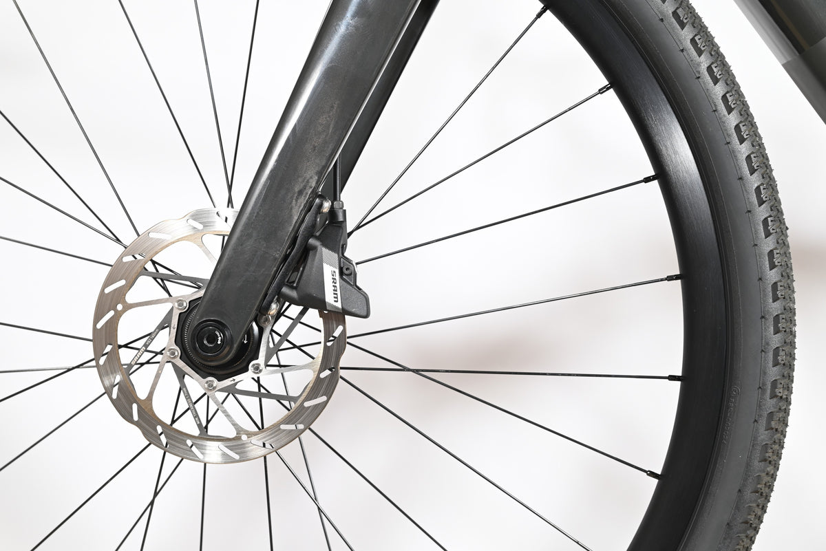 Gros plan sur le frein à disque hydraulique SRAM et la fourche en carbone du vélo gravel Loop Sports Scott Solace