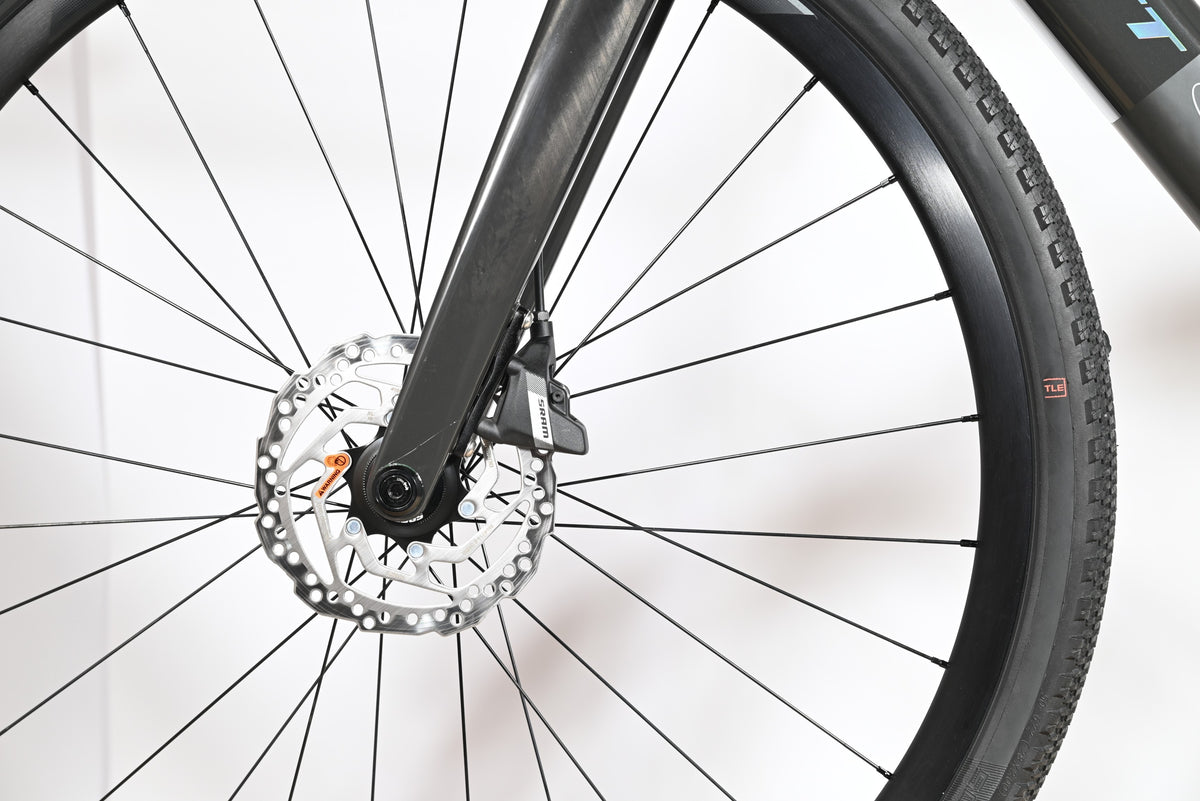 Gros plan sur le frein à disque hydraulique SRAM et la fourche en carbone du vélo gravel Loop Sports Scott Solace
