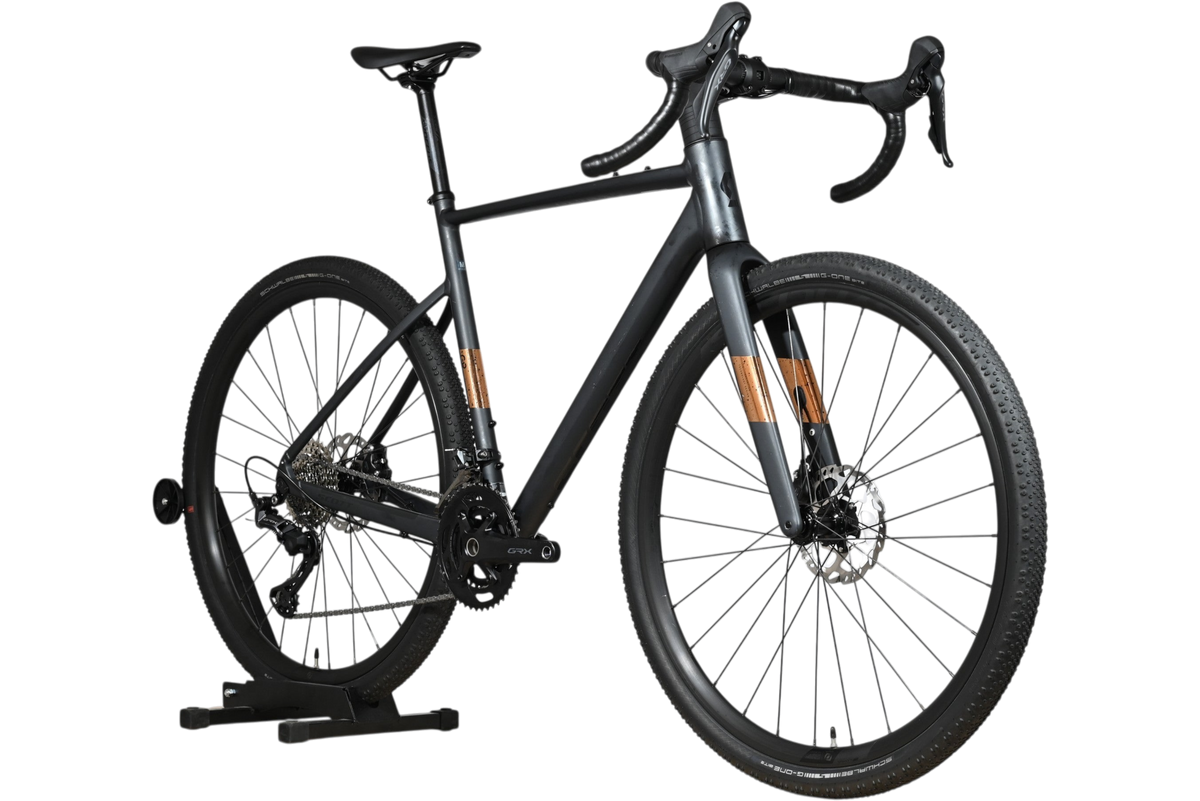 Vélo gravel Scott Speedster Gravel 10 2025 gris mat avec détails en bois, présenté par Loop Sports sur un socle en bois.