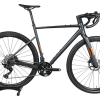 Vélo de gravel Loop Sports Scott Speedster Gravel 10 gris mat avec transmission Shimano GRX sur socle en bois