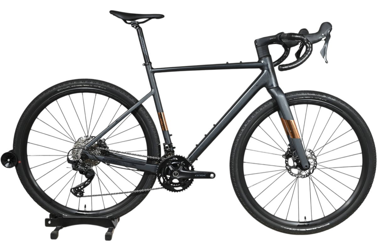 Vélo de gravel Loop Sports Scott Speedster Gravel 10 gris mat avec transmission Shimano GRX sur socle en bois