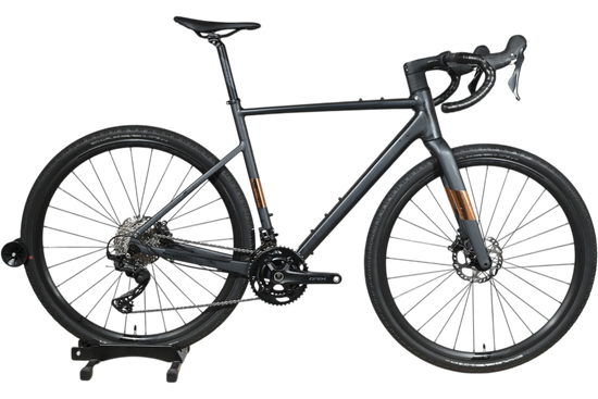 Vélo de gravel Loop Sports Scott Speedster Gravel 10 gris mat avec transmission Shimano GRX sur socle en bois