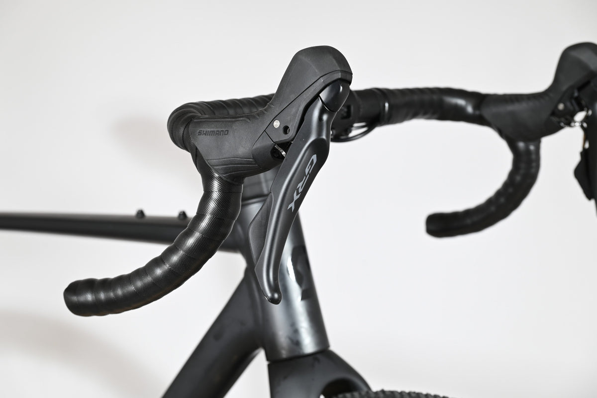 Leviers de frein Shimano GRX noirs sur le cintre de course du vélo gravel Scott Speedster Gravel 10 chez Loop Sports