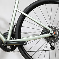 Gros plan sur la transmission et le frein à disque arrière du vélo de route Loop Sports Scott Speedster 20 vert clair