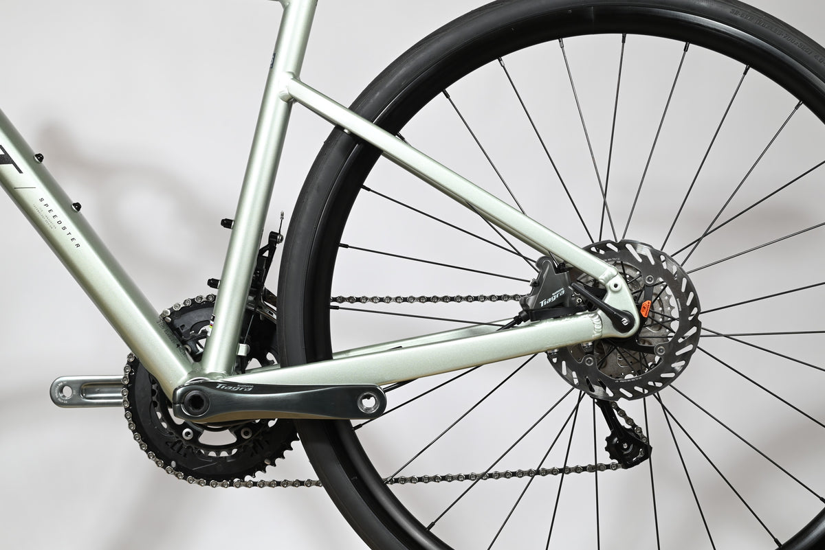 Gros plan sur la transmission et le frein à disque arrière du vélo de route Loop Sports Scott Speedster 20 vert clair