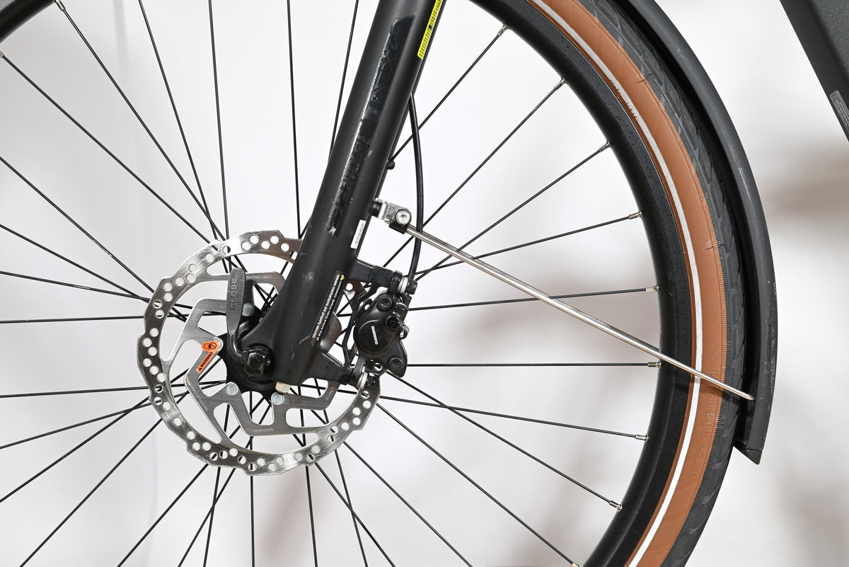 Gros plan sur le frein à disque hydraulique Shimano et la roue avant du vélo électrique Loop Sports Scott Sub Active 20