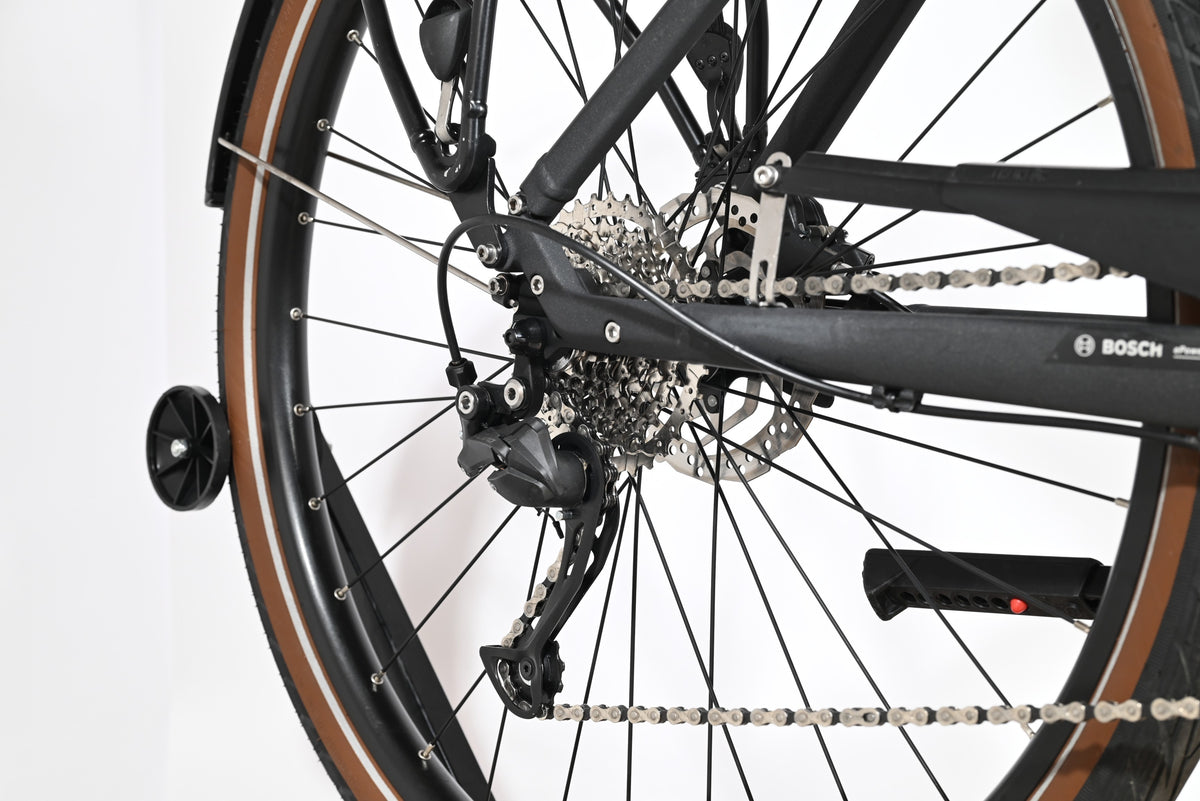 Gros plan sur la roue arrière et la transmission du vélo électrique Loop Sports Scott Sub Active 20 avec pneus marron