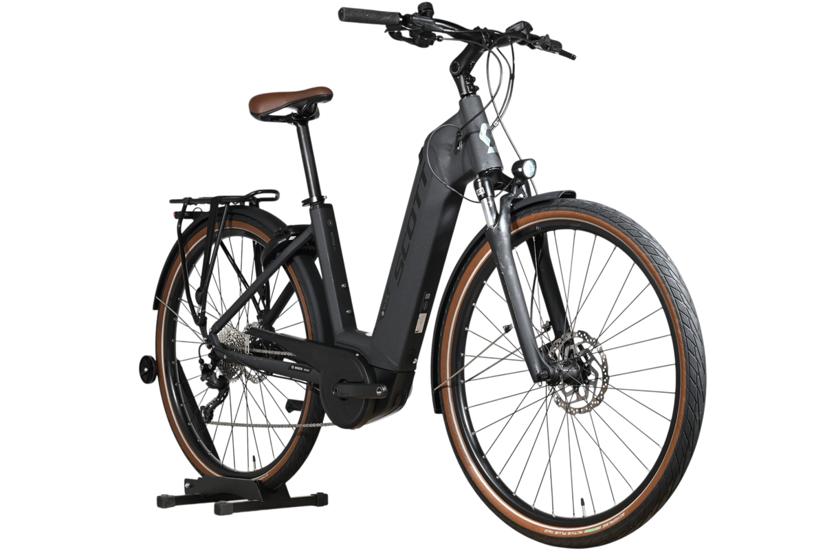 Vélo électrique Loop Sports Scott Sub Active 20 noir avec selle et flancs de pneus marron sur support en bois