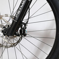 Gros plan sur la roue avant, la fourche RockShox Psylo Gold et le frein à disque Formula Cura du vélo Loop Sports Sunn Charger S1