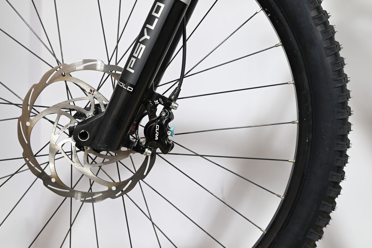 Gros plan sur la roue avant, la fourche RockShox Psylo Gold et le frein à disque Formula Cura du vélo Loop Sports Sunn Charger S1