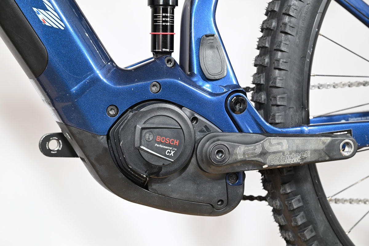 Gros plan sur le moteur Bosch Performance Line CX et le cadre bleu du vélo électrique Loop Sports Sunn Charger S1