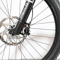 Gros plan sur la roue avant, le disque de frein et la fourche Psyllo du vélo électrique Loop Sports Sunn Charger S1