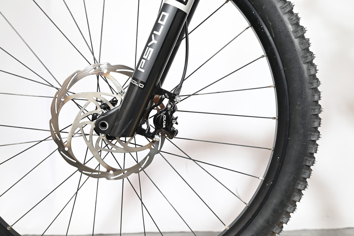 Gros plan sur la roue avant, le disque de frein et la fourche Psyllo du vélo électrique Loop Sports Sunn Charger S1