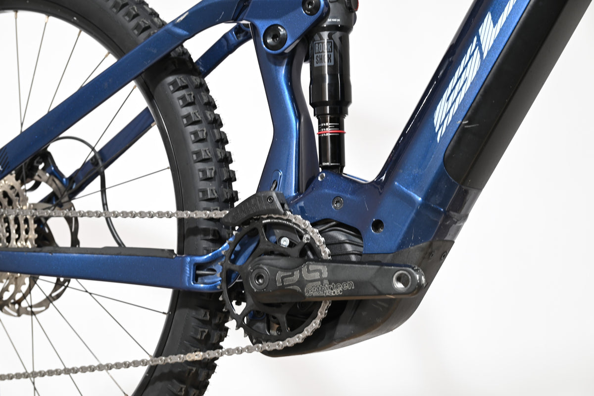 Gros plan sur le cadre bleu et le moteur électrique du vélo tout-terrain Loop Sports Sunn Charger S1 avec amortisseur