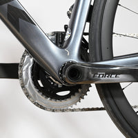 Gros plan sur le pédalier SRAM Force et le cadre gris du vélo de route Trek Emonda SL7 AXS chez Loop Sports