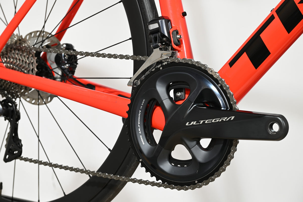 Gros plan sur le pédalier Shimano Ultegra et le cadre rouge vif du vélo de route Trek Emonda SL 7 Loop Sports