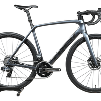 Vélo de route Trek Emonda SL7 AXS 2023 gris carbone chez Loop Sports sur un support en bois