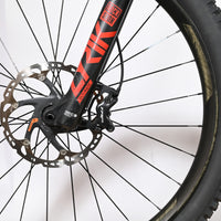 Gros plan sur la roue avant et la fourche RockShox noire et rouge du vélo électrique Trek Rail 9.9 chez Loop Sports