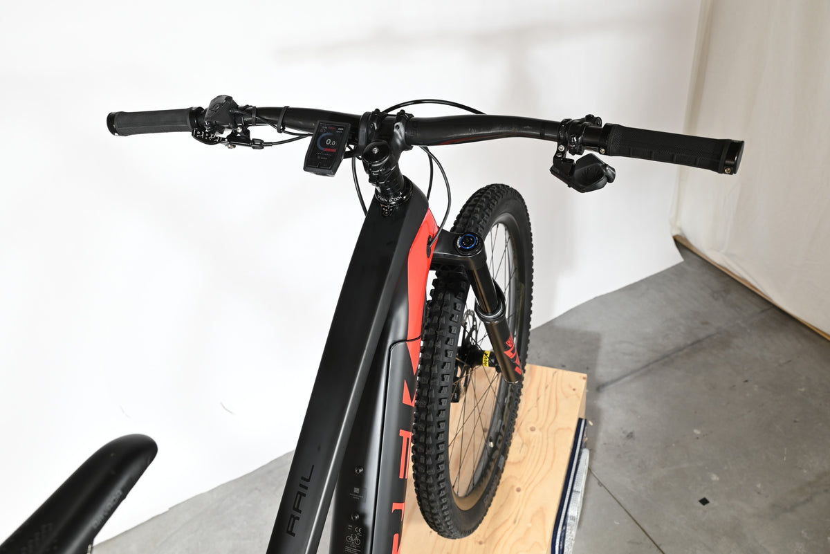 Vue rapprochée du guidon et du cadre noir et rouge du vélo électrique Trek Rail 9.9 2024 chez Loop Sports