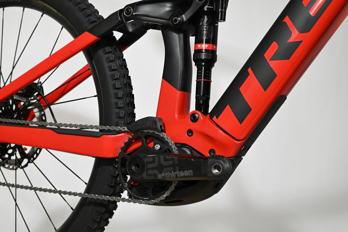 Gros plan sur le cadre rouge et noir du vélo électrique Trek Rail 9.9 2024 chez Loop Sports avec amortisseur arrière