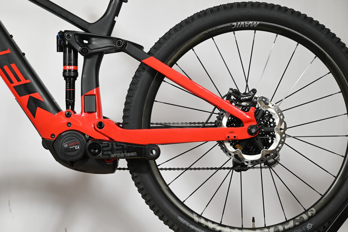 Vue latérale du cadre et de la roue arrière du vélo électrique Loop Sports Trek Rail 9.9 rouge et noir