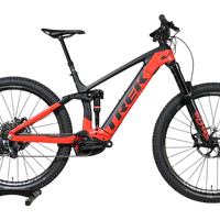VTT électrique Trek Rail 9.9 2024 rouge et noir de Loop Sports sur un socle en bois