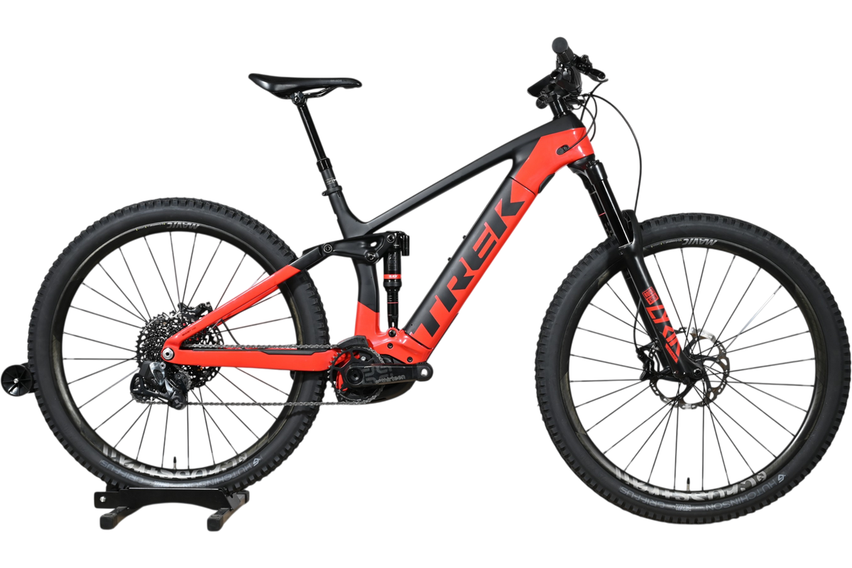 VTT électrique Trek Rail 9.9 2024 rouge et noir de Loop Sports sur un socle en bois