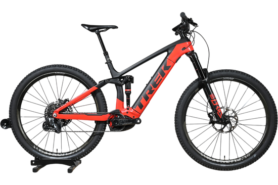 VTT électrique Trek Rail 9.9 2024 rouge et noir de Loop Sports sur un socle en bois