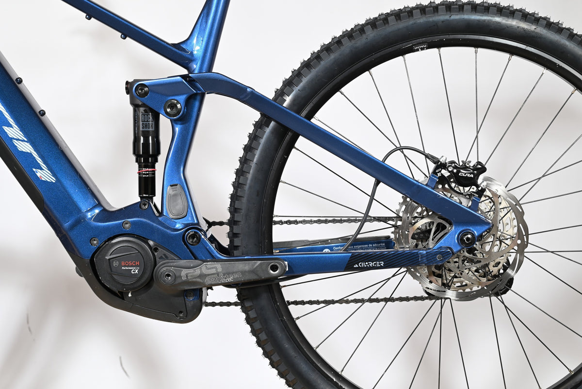 Vue latérale arrière du vélo électrique bleu Sunn Charger S1 de Loop Sports avec moteur Bosch et suspension RockShox