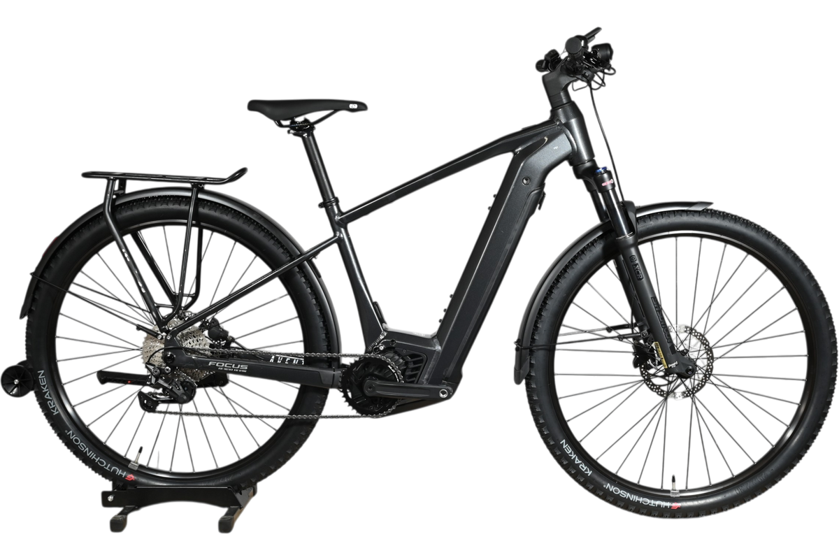 Vélo électrique Focus Aventura 6.7 noir de Loop Sports avec porte-bagages et garde-boue sur un socle en bois