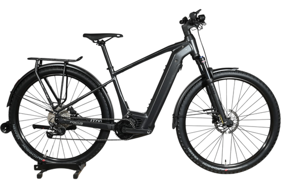 Vélo électrique Focus Aventura 6.7 noir de Loop Sports avec porte-bagages et garde-boue sur un socle en bois
