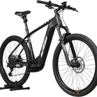 Velo electrique Loop Sports KTM Macina Team noir mat avec cadre robuste et pneus tout-terrain sur support en bois