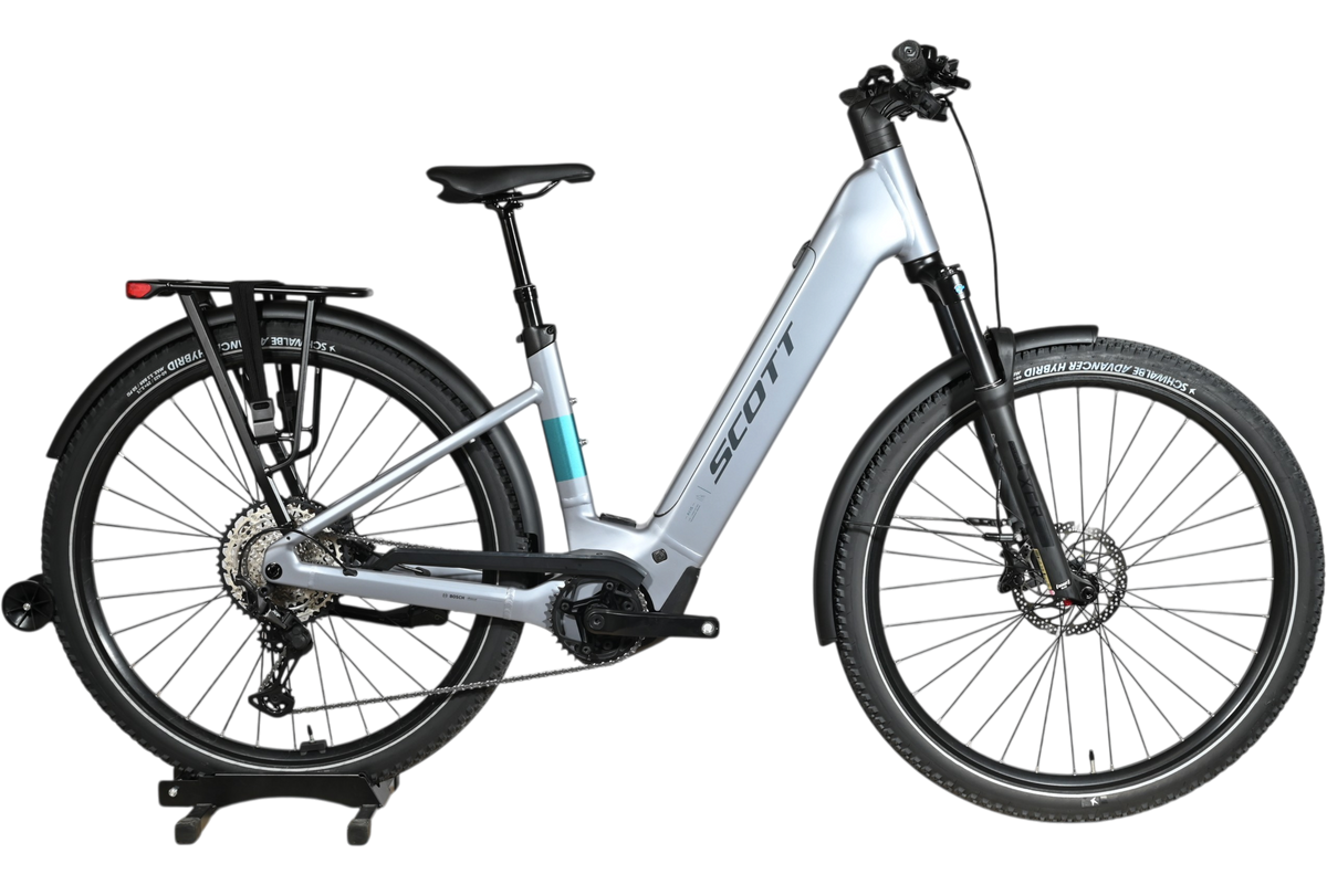 Vélo électrique Scott Axis 10 2026 gris clair avec porte-bagages, vendu par Loop Sports sur un socle en bois