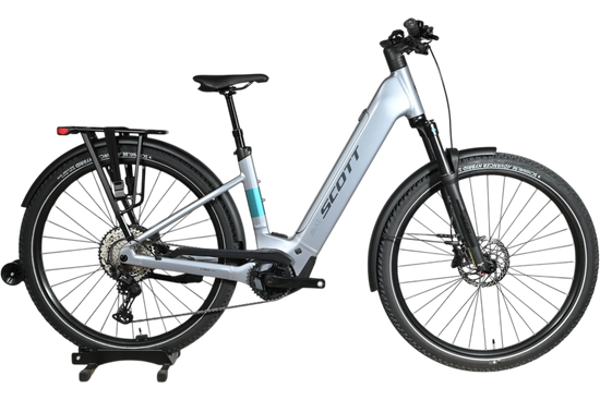 Vélo électrique Scott Axis 10 2026 gris clair avec porte-bagages, vendu par Loop Sports sur un socle en bois