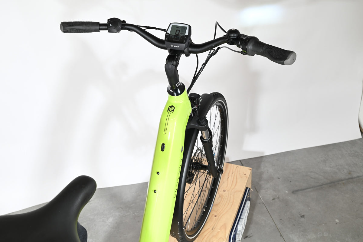 Vue rapprochée du guidon et du cadre vert lime du vélo électrique Victoria eManufaktur 11.7 chez Loop Sports