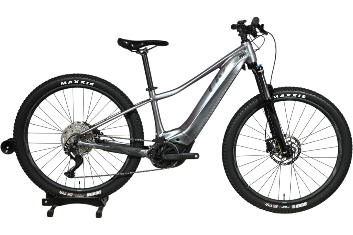 Velo electrique VTT Giant Liv Vall E+2 2025 gris argent de Loop Sports sur support en bois